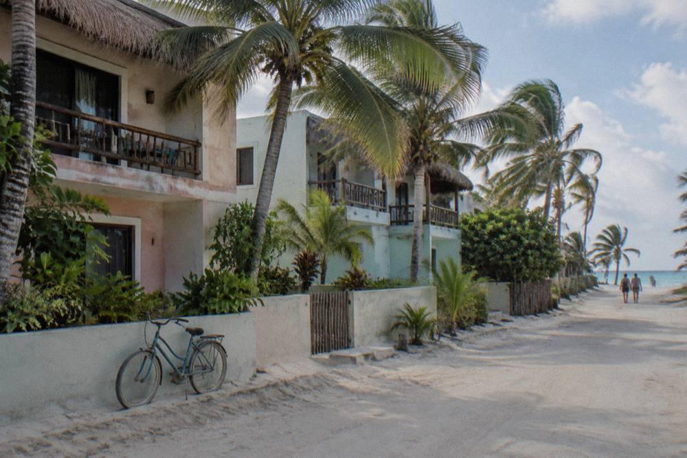 Small Hotel Buildings Along A Beach Road With Palm Trees