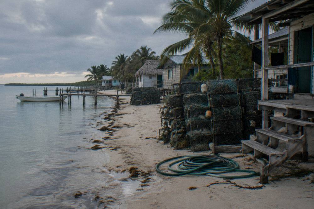 Fishing village of small wooden houses along a sandy spit beside a calm bay