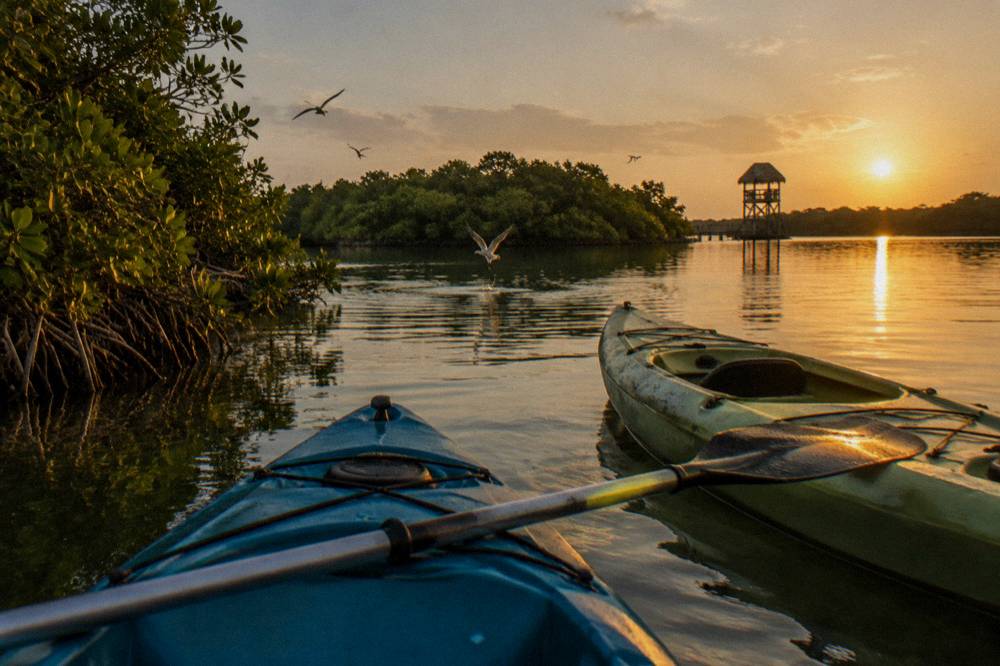 Two kayaks on calm lagoon water at golden hour